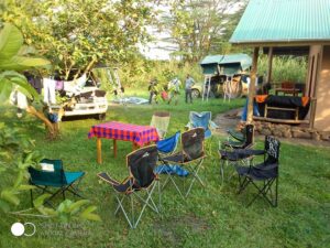 A scenic view of simple, comfortable eco-tourism cottages surrounded by lush green trees at Nguse River Camp.