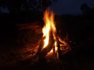 The outdoor dining terrace and restaurant at Nguse River Camp with a central evening campfire pit
