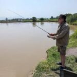 A fishing excursion setup on the lush, green riverbanks of the Semliki River in Bweramule, Uganda
