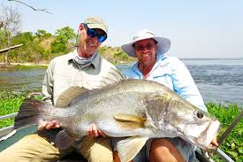 Customized sport fishing boat navigating the turbulent waters of the Victoria Nile River below Murchison Falls.