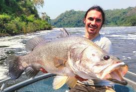 Customized sport fishing boat navigating the turbulent waters of the Victoria Nile River below Murchison Falls.