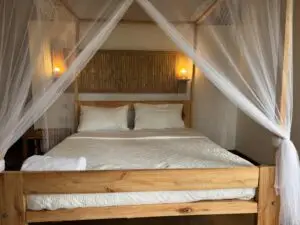 A classic canvas safari tent pitched on a raised wooden platform, featuring a private veranda facing the wilderness.