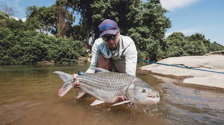 Disabled Uganda Fishing Safaris | Accessible Fishing Tours Angler holding a Tiger Fish in Uganda